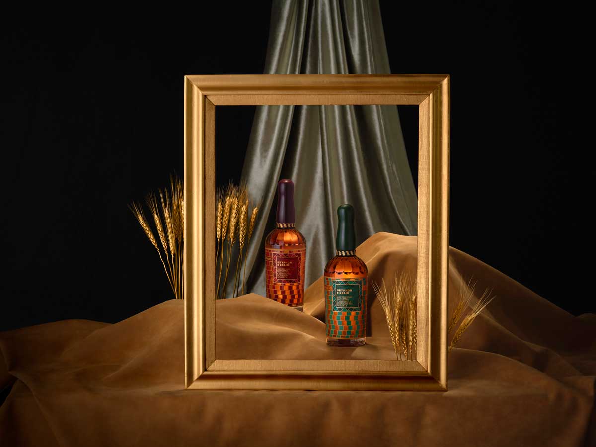 Gryphon and Grain bottles within gold frame